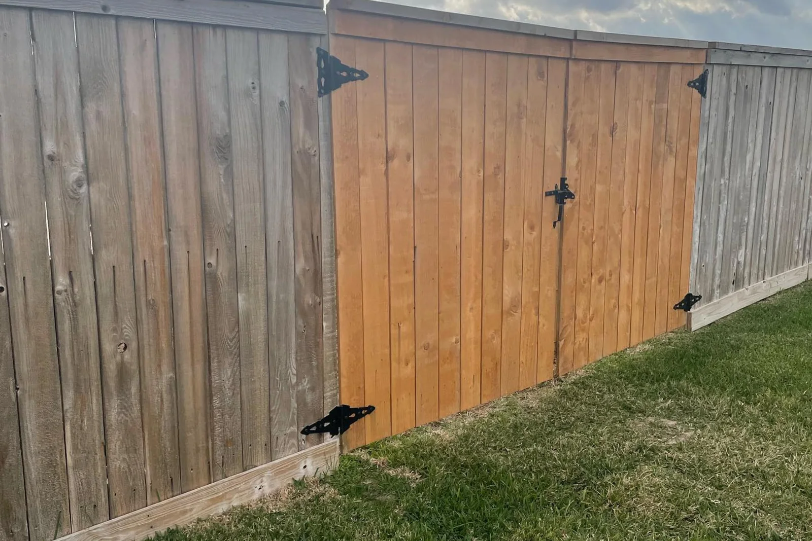 A finished wood privacy fence with a matching gate