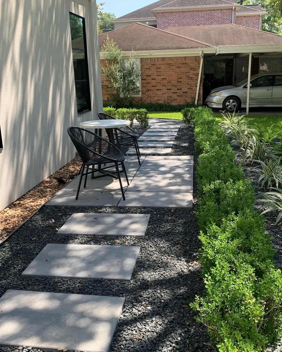 Side courtyard with paver path, bistro table and a clipped boxwood border